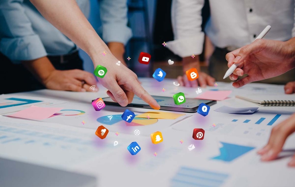 Team analyzing a social media content strategy with icons hovering over a digital tablet.